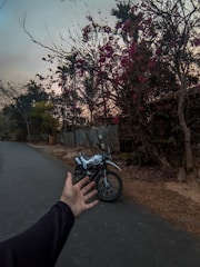 A technician assisting a motorcyclist during a roadside rescue at sunset.