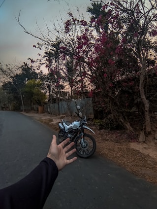A technician assisting a motorcyclist during a roadside rescue at sunset.