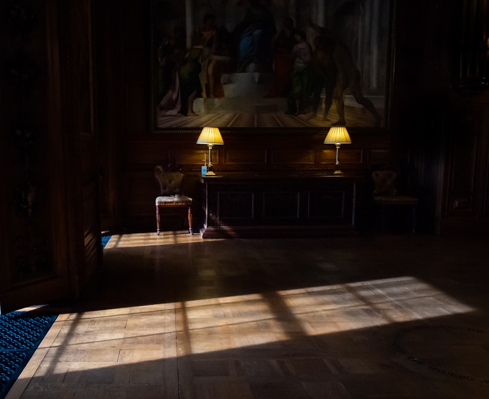 a room with two lamps and a painting on the wall