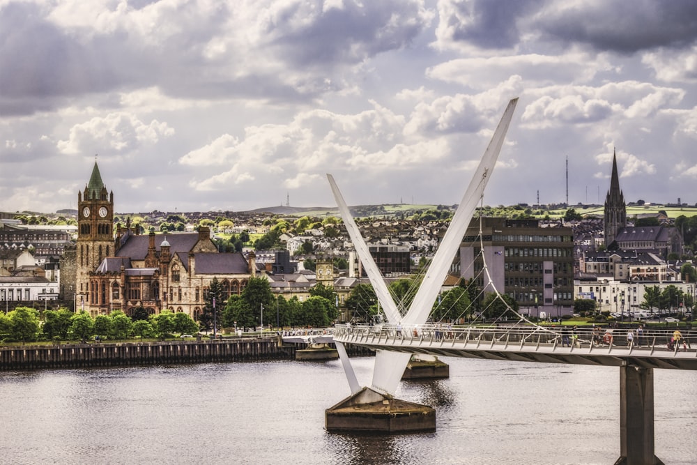 a bridge over a river with a city in the background