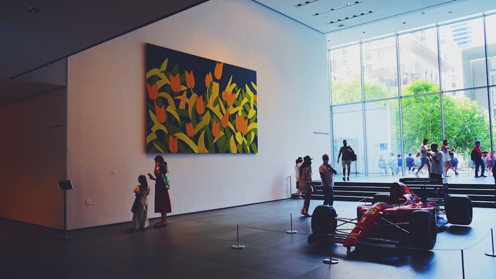 a group of people standing in front of a painting