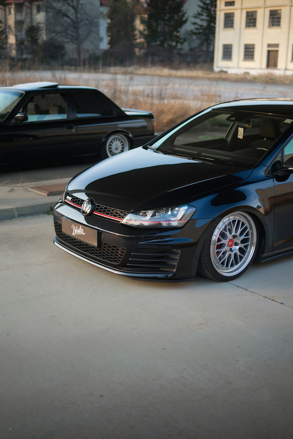 a black car is parked in a parking lot