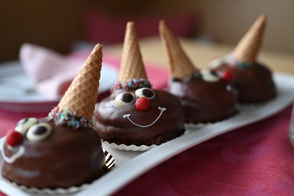 a plate of chocolate covered desserts with cones on top of them