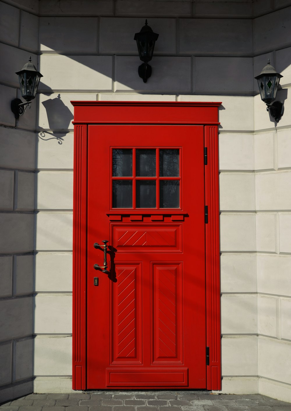 Una puerta roja con una pared de ladrillo detrás
