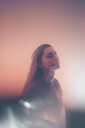 A serene portrait of a person smiling in natural light.