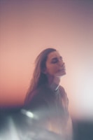 A serene portrait of a person smiling in natural light.