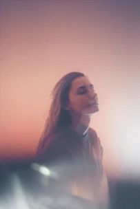 A serene portrait of Shri Mataji Nirmala Devi radiating peaceful energy against a minimalist white background