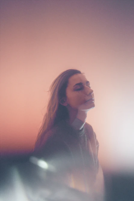 A serene portrait of a thoughtful woman surrounded by soft earthy tones, embodying calm and reflection.