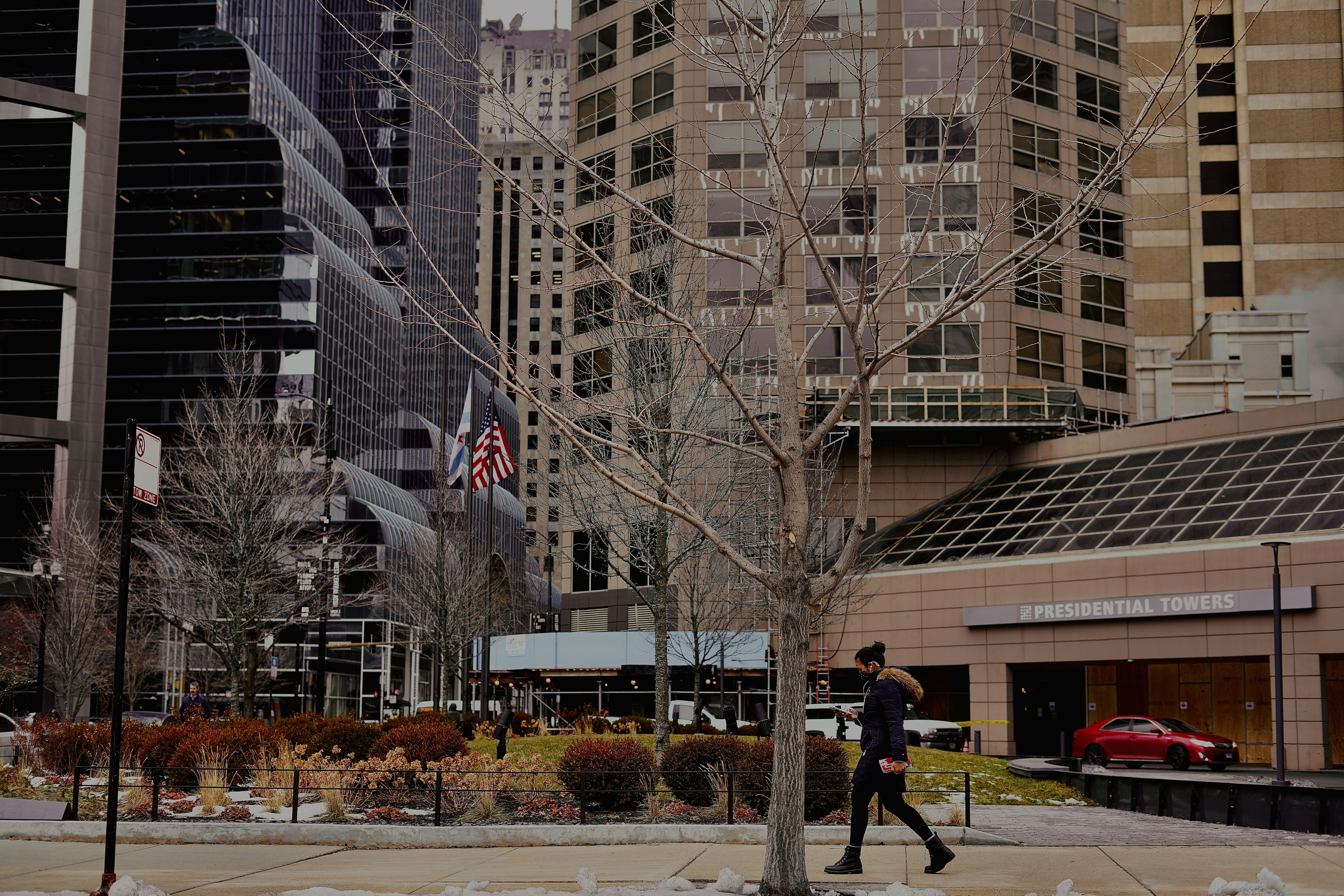 a man walking down a street next to tall buildings