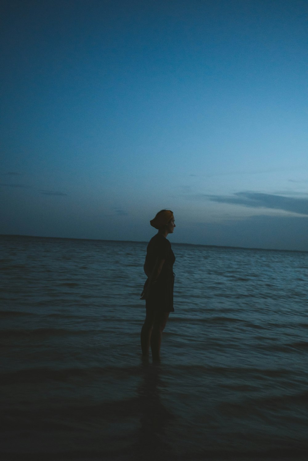 a person standing in the ocean at night