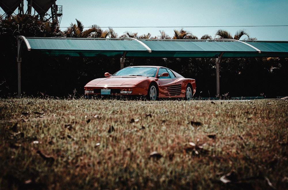 a red sports car parked in front of a green awning