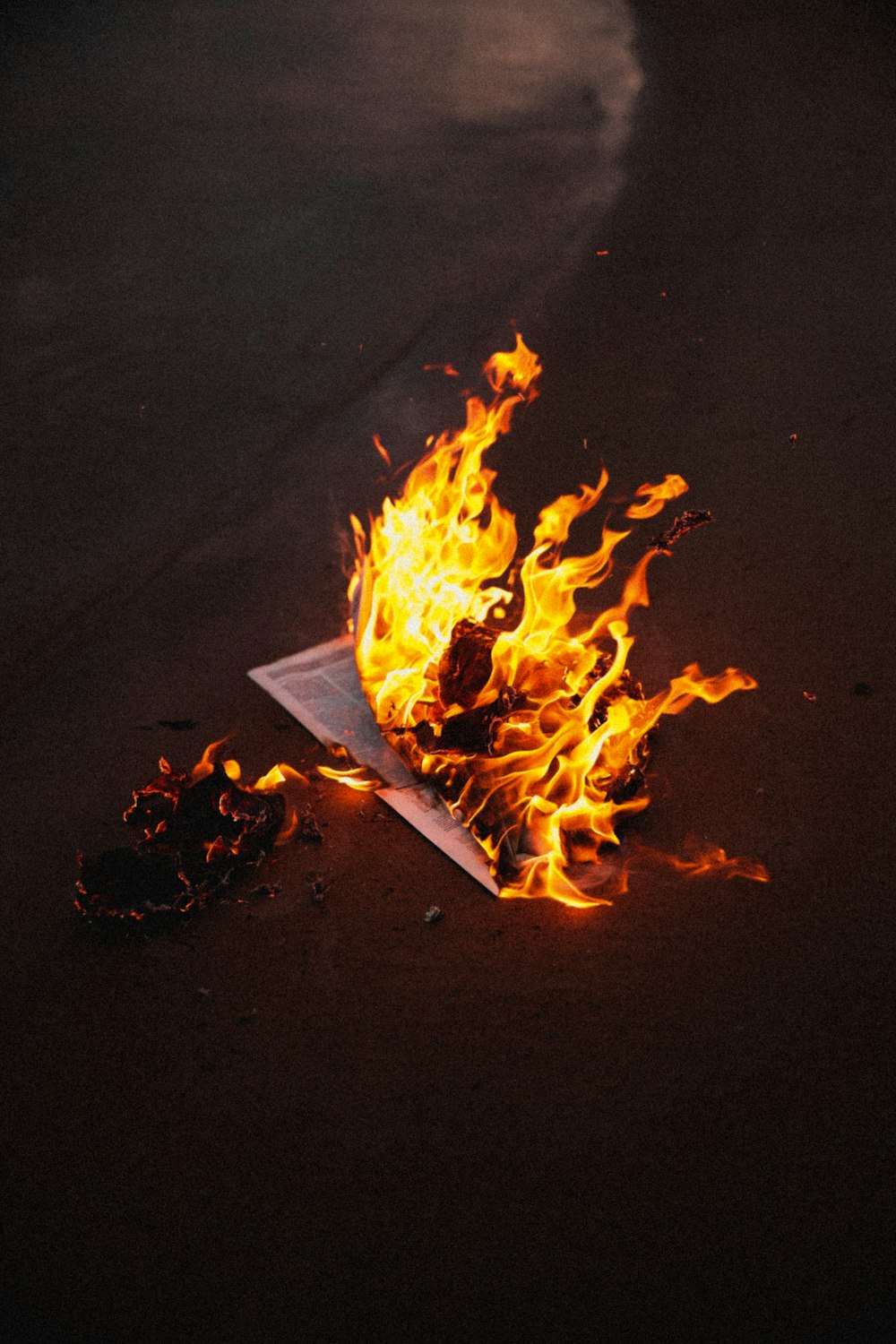 a burning piece of paper on a beach