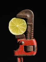 a lime slice is being held in a wrench