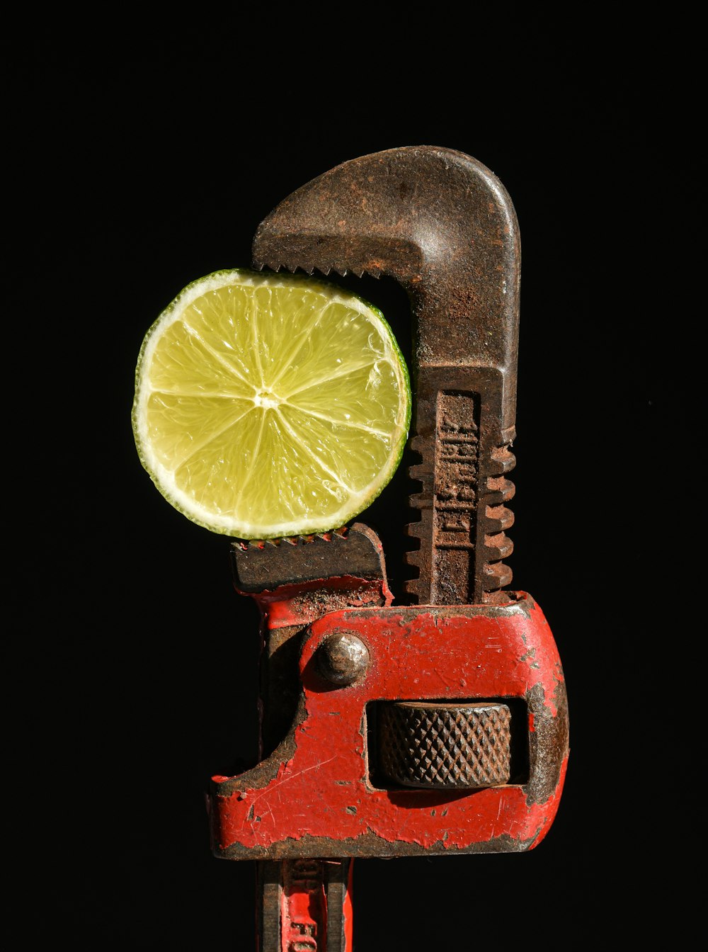 a lime slice is being held in a wrench