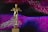 A golden statue resembling an award is centrally placed against a dynamic background of swirling patterns in shades of pink, purple, and blue. The statue stands on a base with the phrase 'DO WHATEVER IT TAKES' engraved on it.