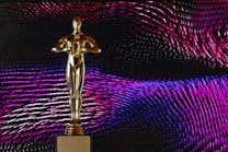 A golden statue resembling an award is centrally placed against a dynamic background of swirling patterns in shades of pink, purple, and blue. The statue stands on a base with the phrase 'DO WHATEVER IT TAKES' engraved on it.
