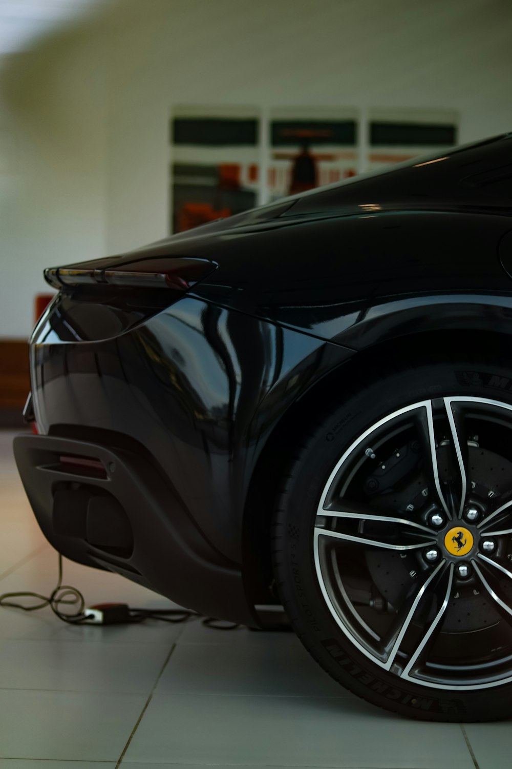 a black sports car is plugged in to a charger