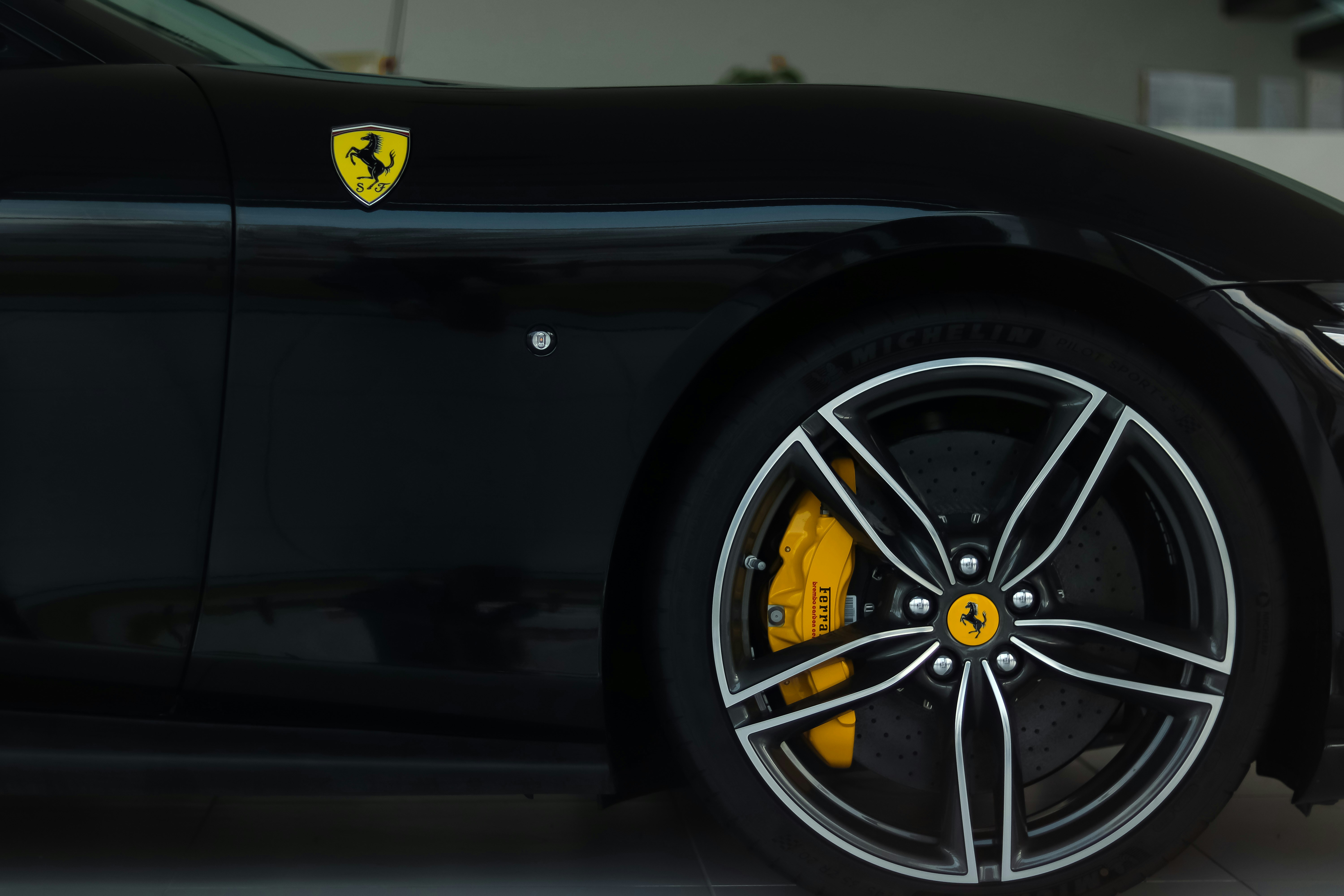 a black sports car with a yellow emblem