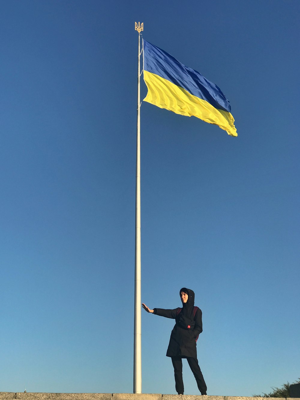 a man standing next to a flag pole