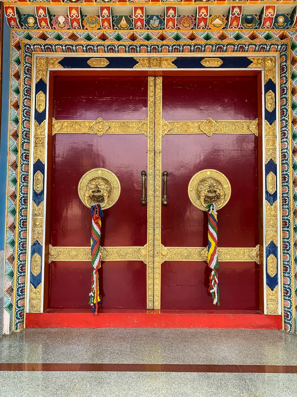 a large red door with two gold handles