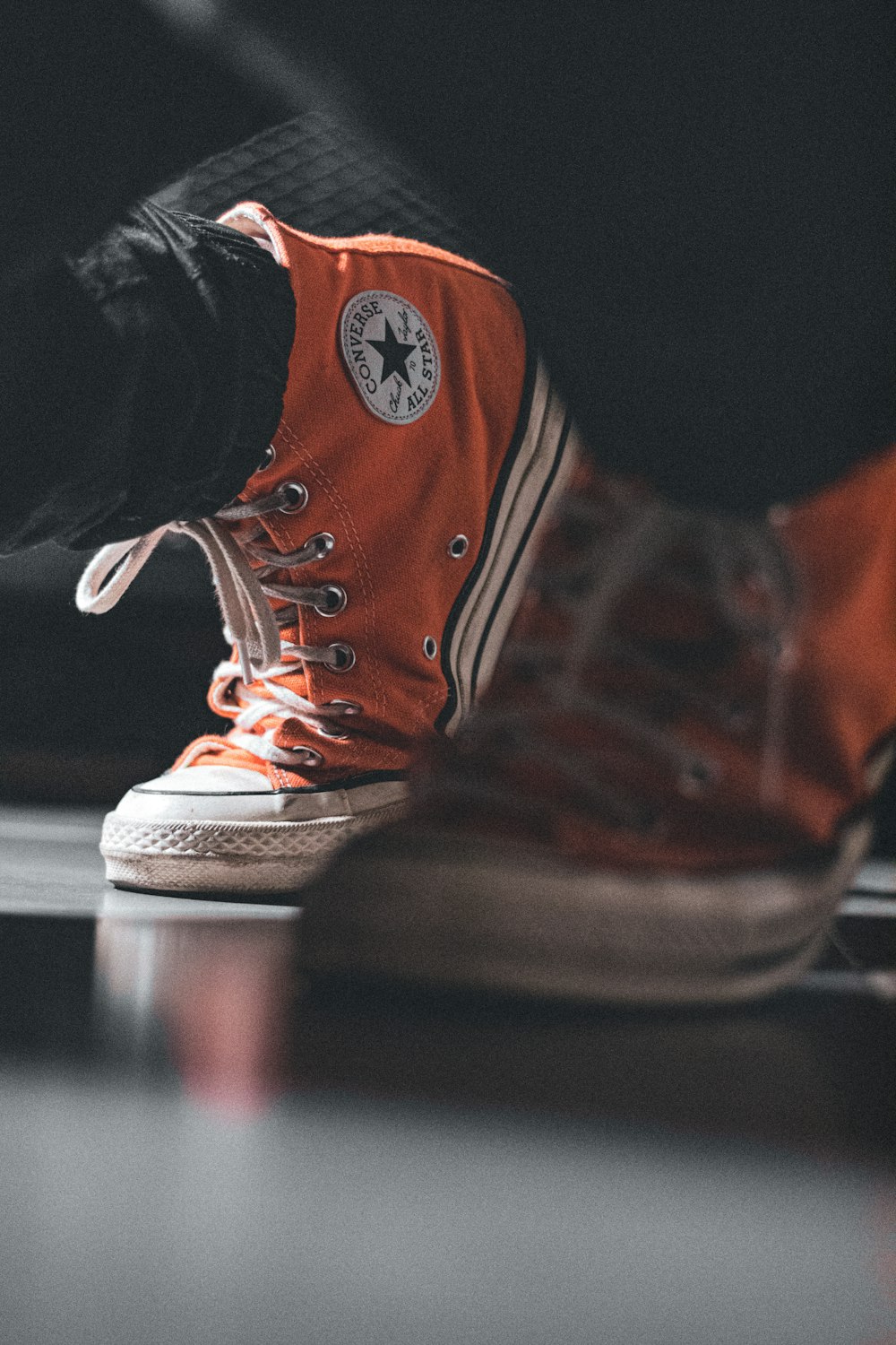 a person's feet with orange sneakers on