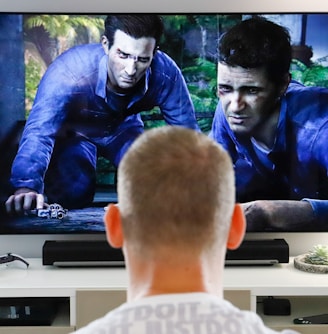 a man watching a movie on tv in his living room