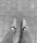 A pair of legs in leggings is visible, wearing sneakers with fur trim, standing on a paved brick pathway. The image is in black and white.
