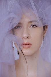 Portrait of a model wearing vintage silk scarves, light filtering through softly. Nouvelle Vague est