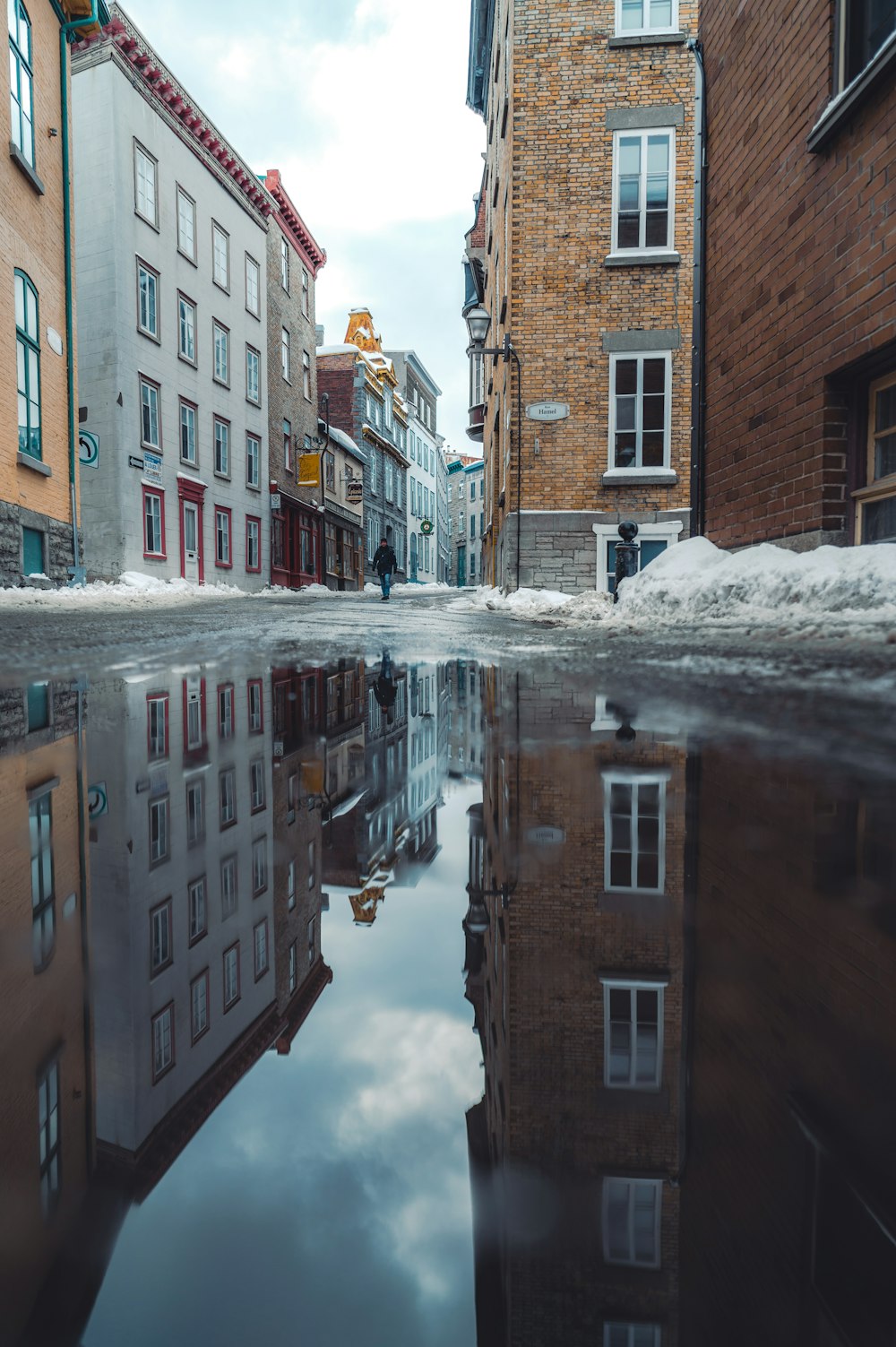 a reflection of buildings in a puddle of water