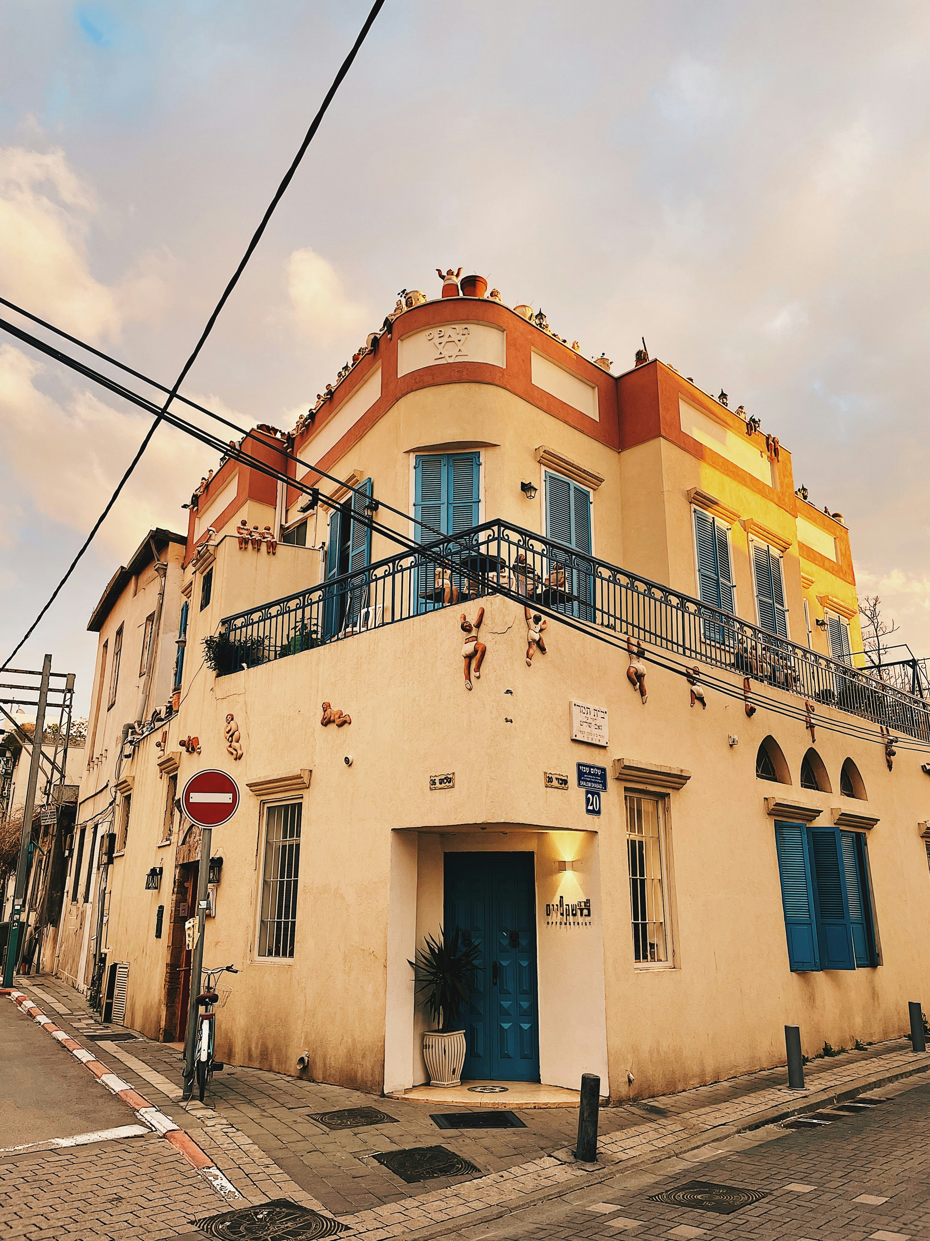 a yellow building with a blue door on a street corner