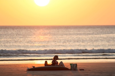 A serene beach sunset with a suitcase and travel journal on the sand.