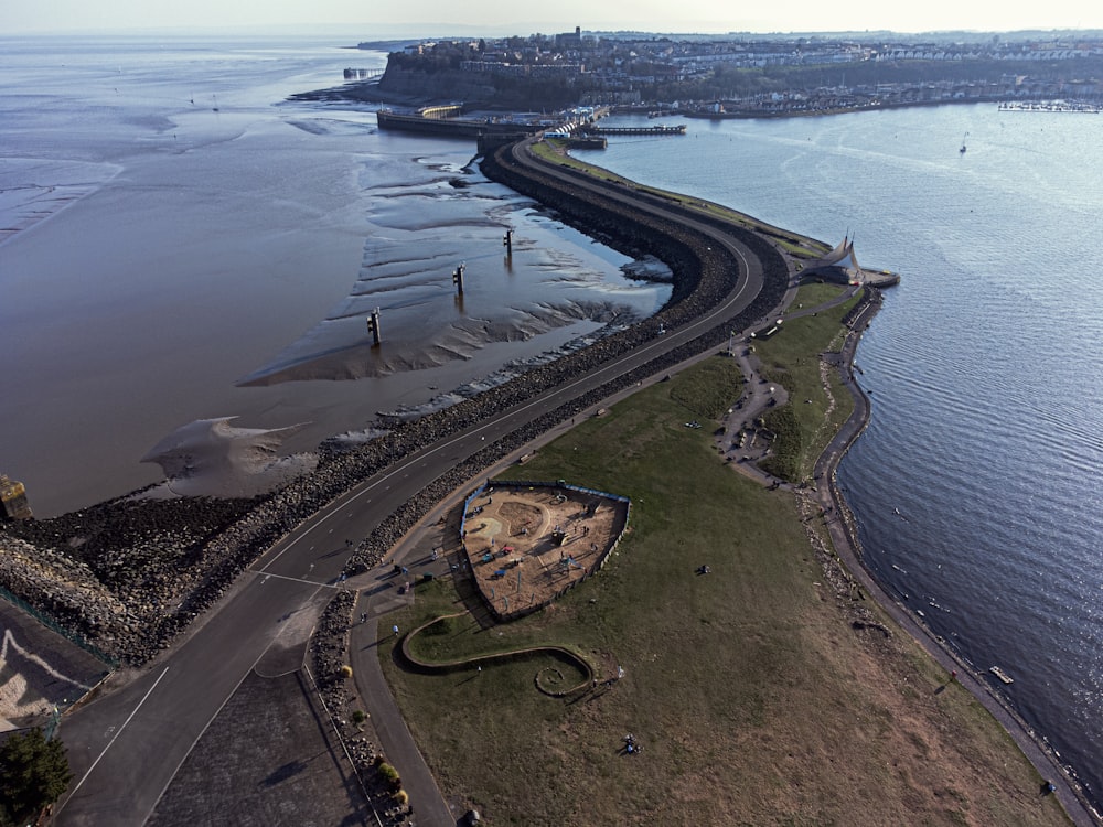 an aerial view of a road next to a body of water