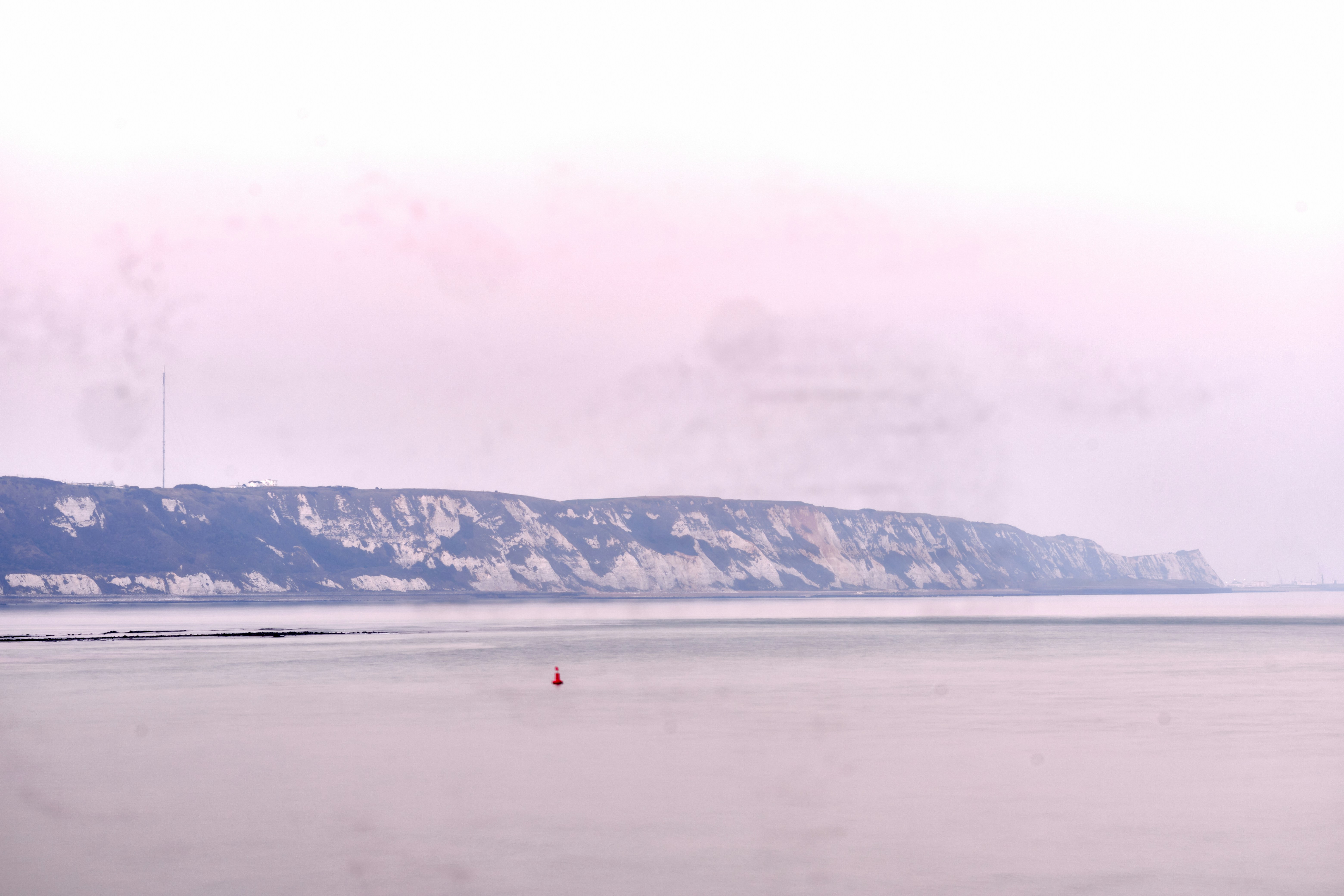a large body of water with a mountain in the background