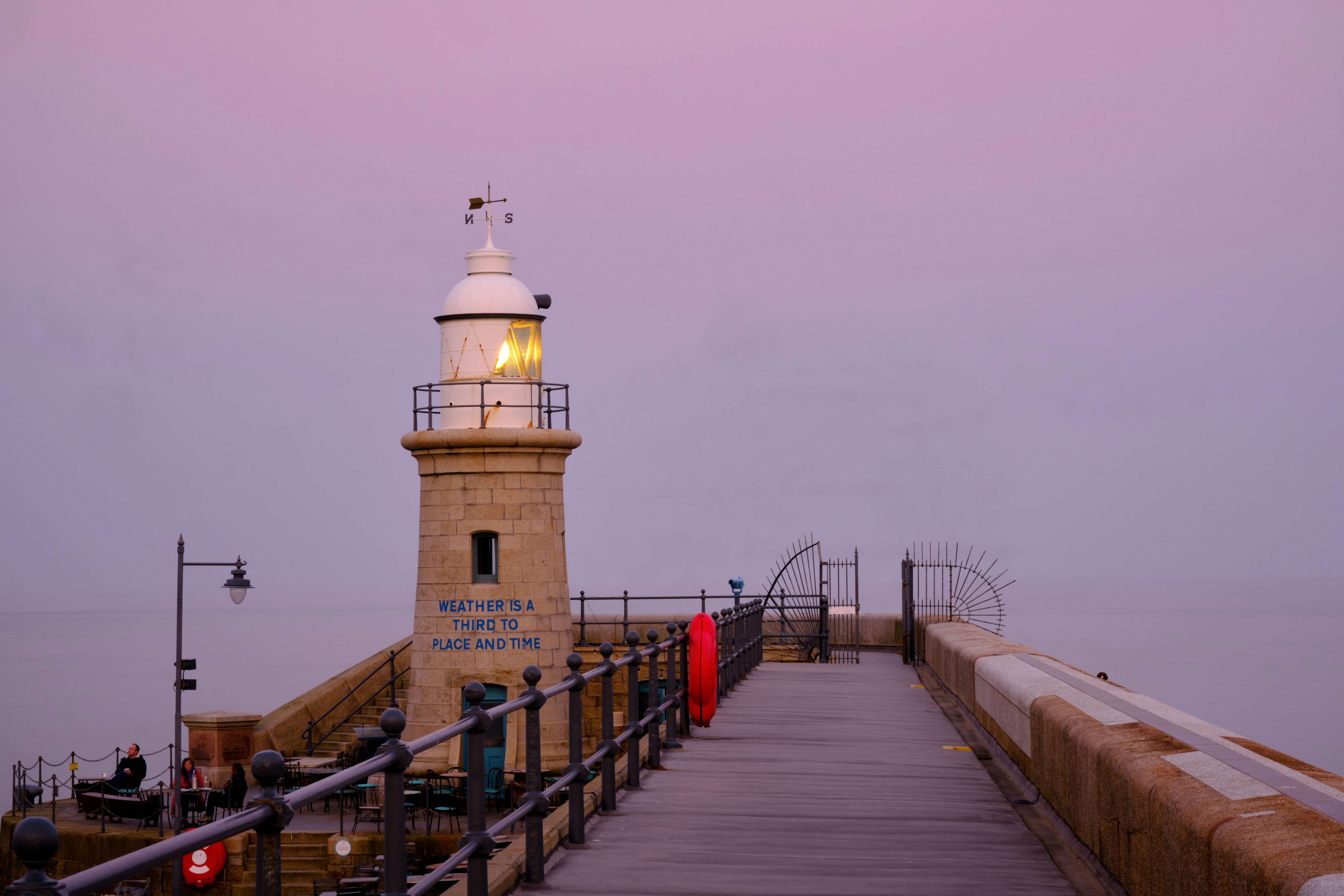 a light house sitting on top of a pier next to the ocean