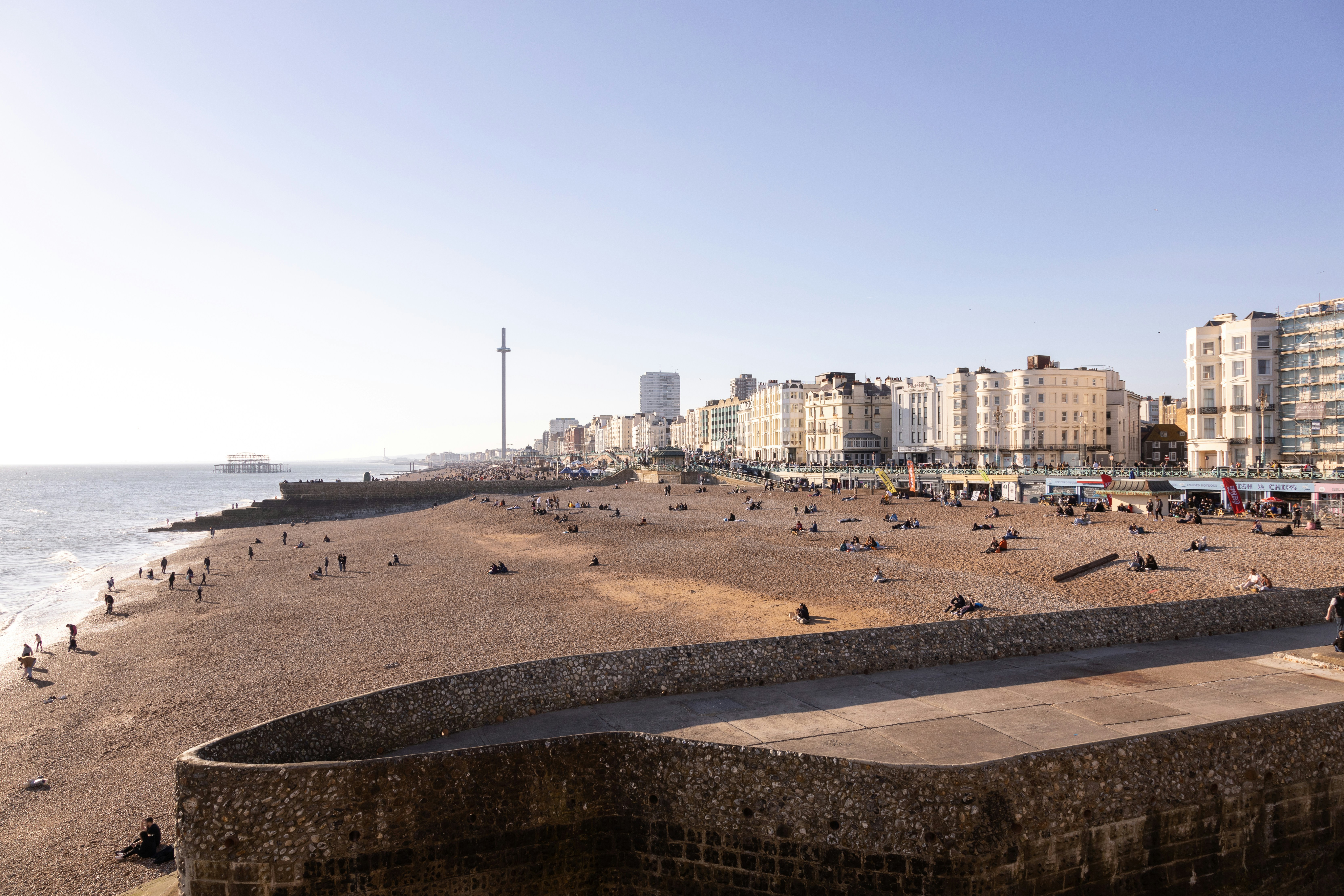 a group of people sitting on top of a sandy beach