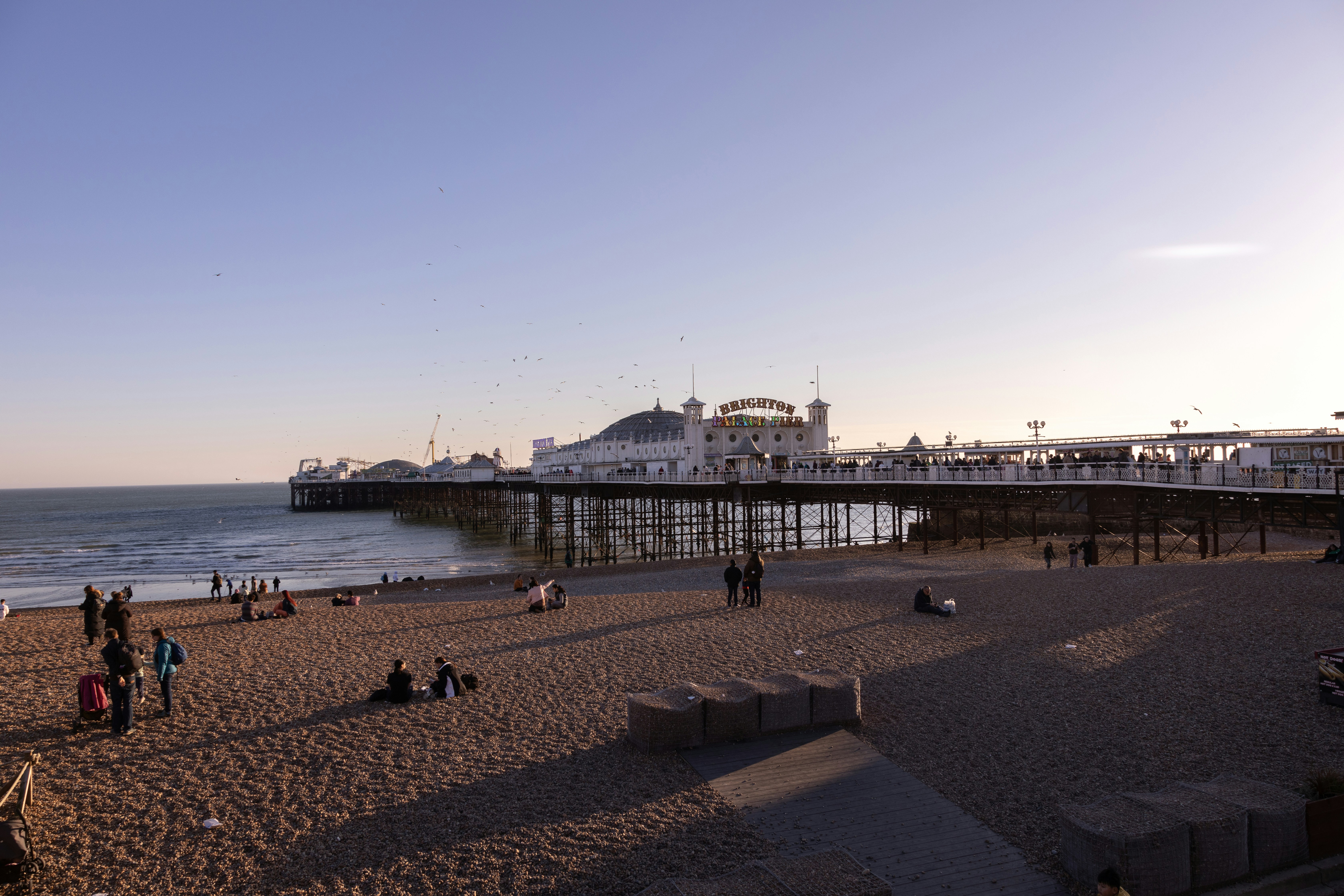 a group of people standing on top of a sandy beach