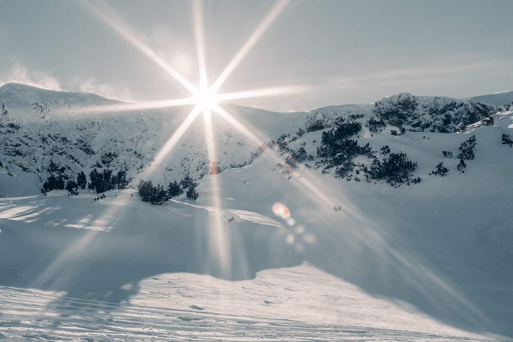 the sun shines brightly over a snowy mountain
