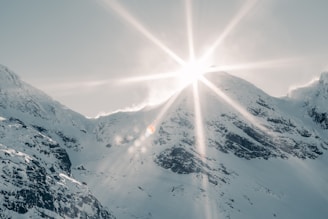 the sun shines brightly over a snowy mountain