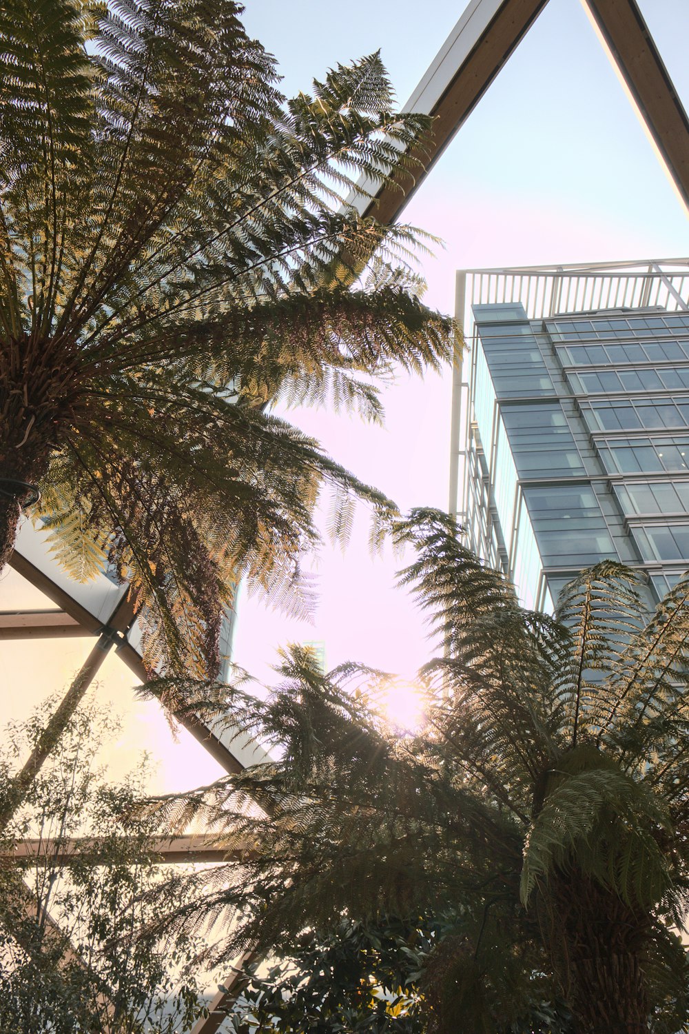 a tall building sitting next to a lush green forest