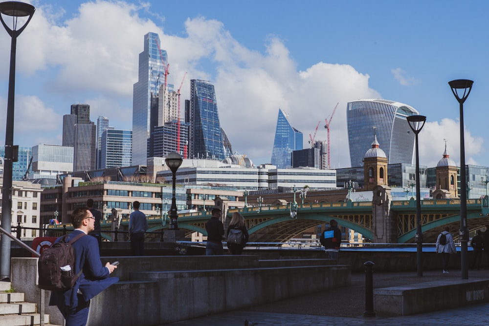 a woman standing on a bridge looking at her cell phone