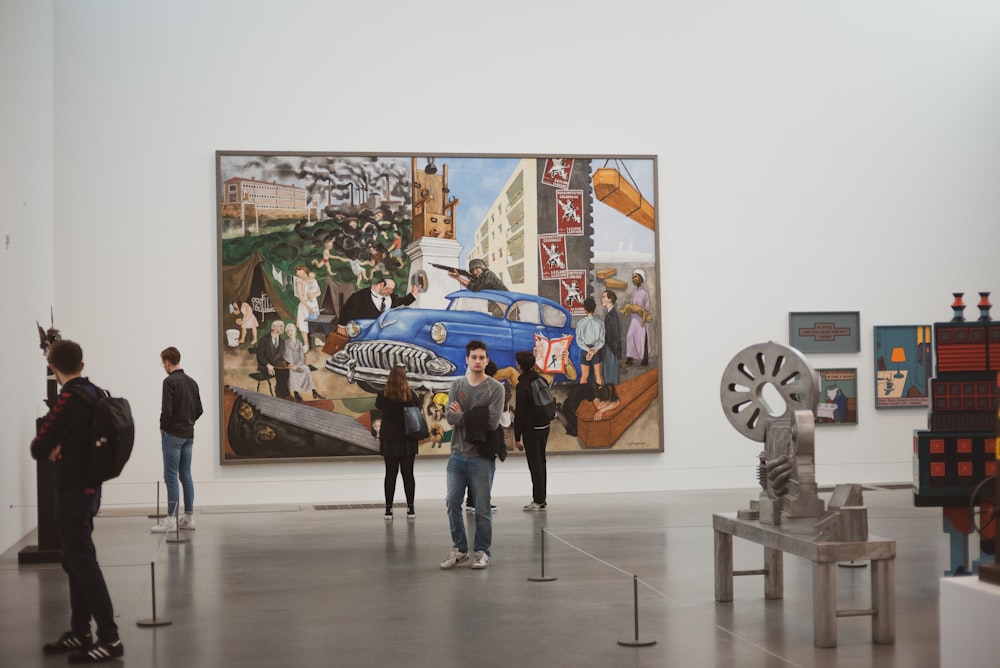 a group of people standing in front of a painting