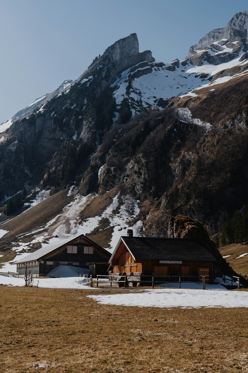 a couple of houses sitting on top of a snow covered field