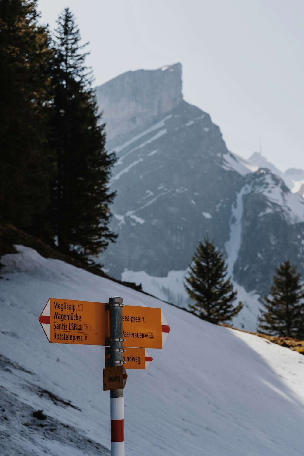 a sign on the side of a snow covered mountain