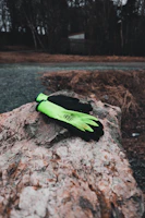 Technical gloves with touchscreen fingertips and waterproof leather palms laid out on icy rocks.