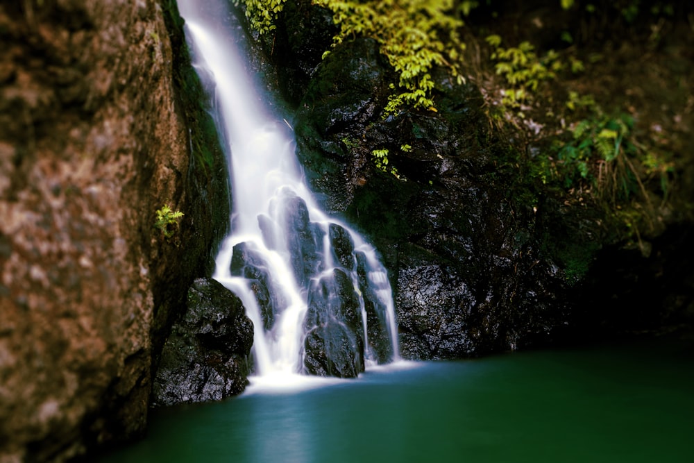 une grande cascade avec de l’eau verte au milieu