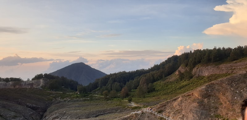 Pendaki menikmati pemandangan bukit hijau dalam perjalanan wisata Danau Kelimutu