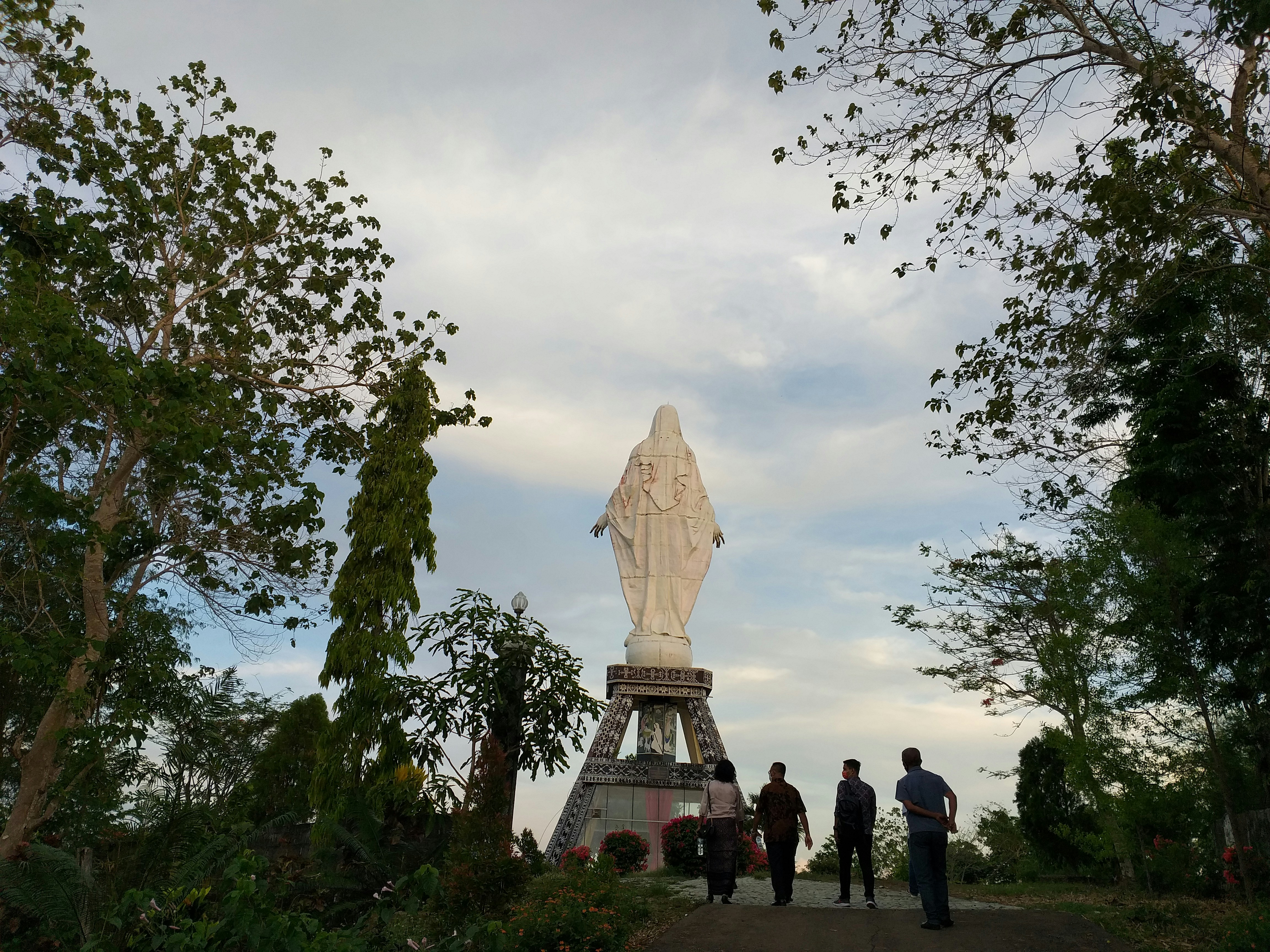 a group of people standing in front of a statue