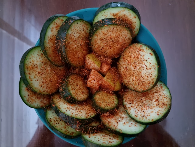 Close-up of a colorful pot filled with layered cucuz topped with fresh ingredients