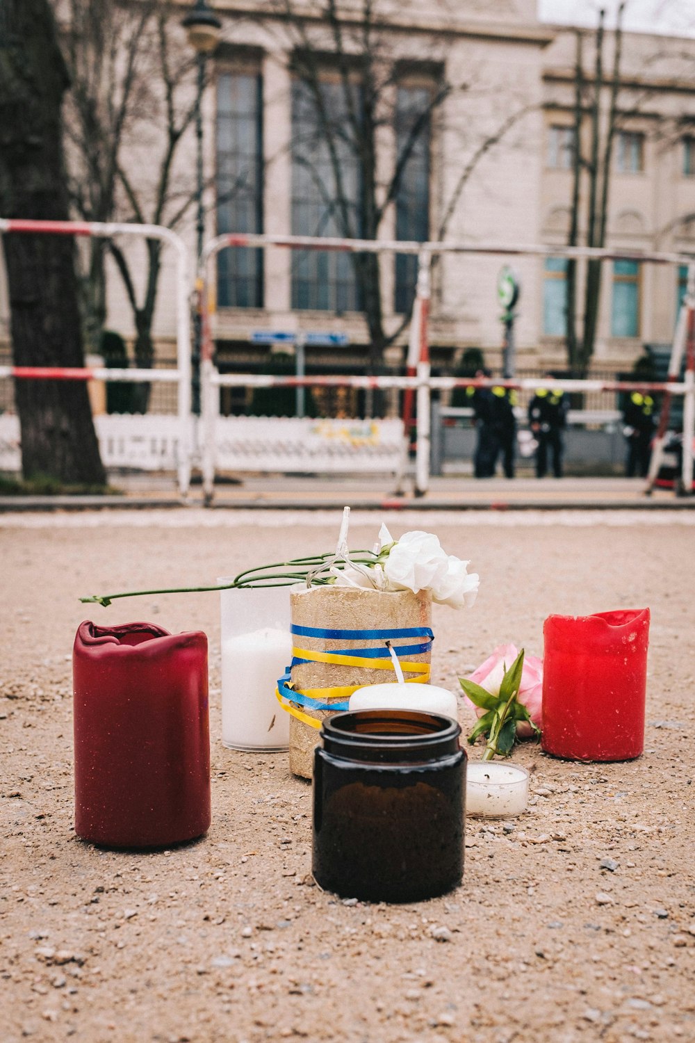 a couple of candles sitting on top of a sandy ground