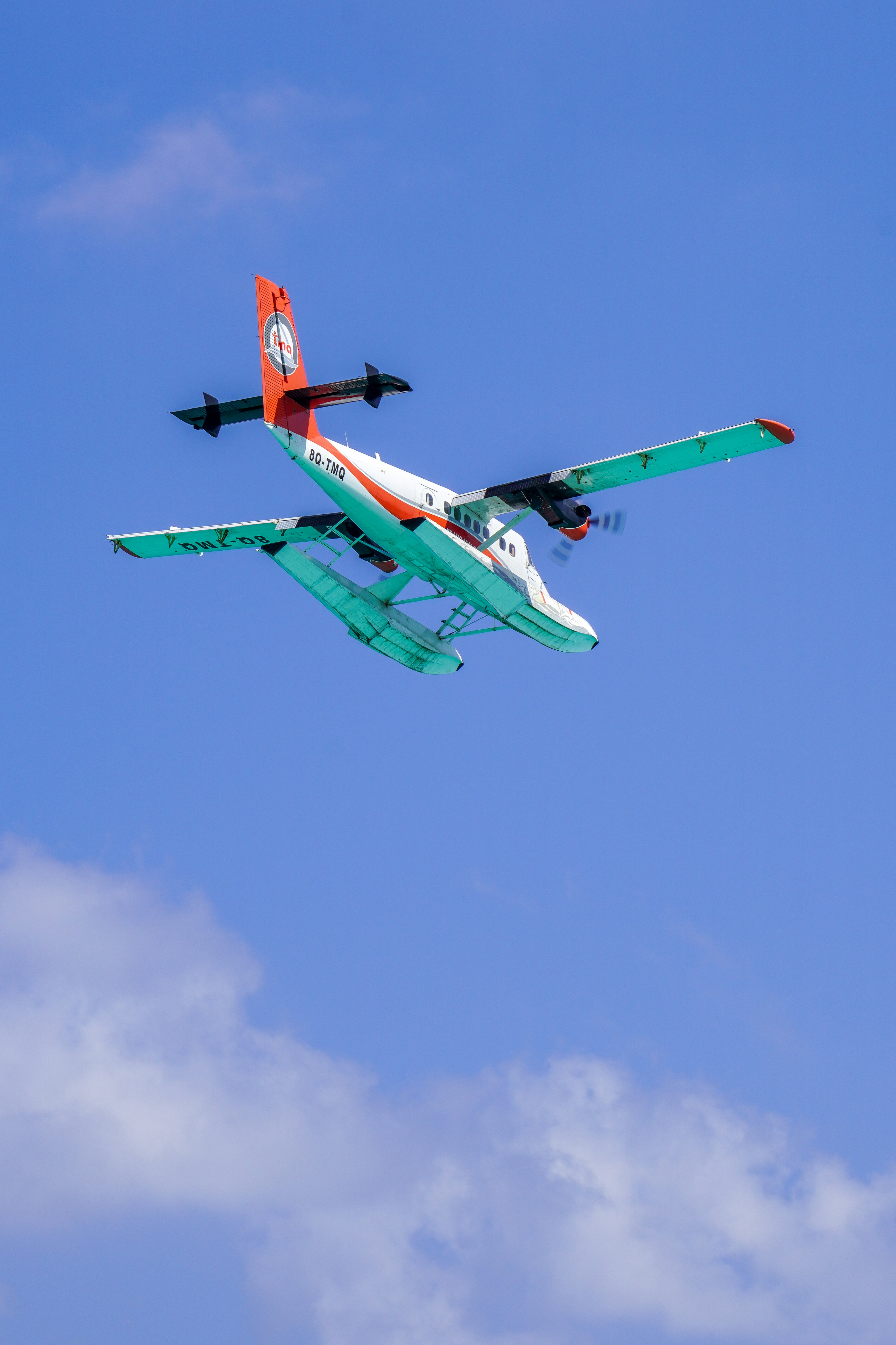 a small airplane flying through a blue sky